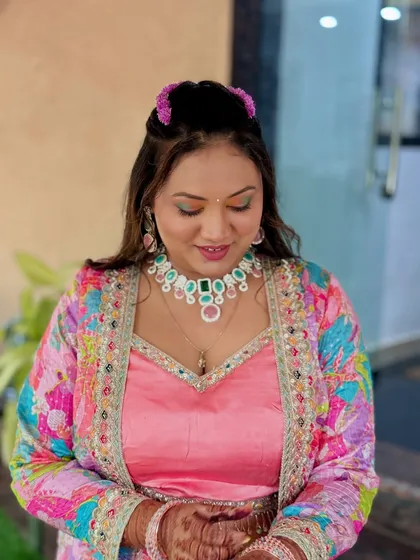 A close-up of the bride's makeup for a pre-wedding event, featuring colorful eyeshadow that matches her vibrant jacket.