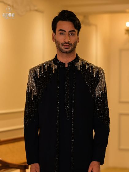 A direct, powerful shot of the black sequined Jodhpuri. The detailing on the shoulders and sleeves is designed to catch the light and create a dramatic effect.