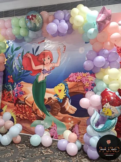 A close-up of the mermaid backdrop and balloon decorations, showing the character foil balloons.