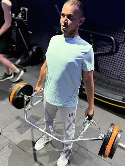 The trap bar deadlift is a fantastic alternative to the conventional deadlift, as it puts less stress on the lower back. This client is shown at the top of the movement, maintaining a strong, upright posture.