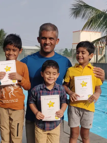 Celebrating progress is a huge part of my coaching. Here I am with some of my youngest swimmers after they've earned their certificates. Seeing their proud smiles is the best reward.