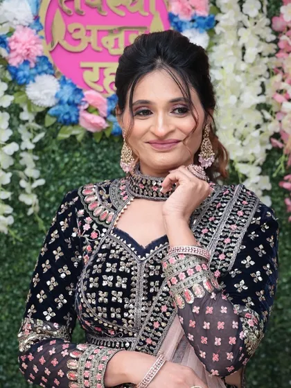 A playful and happy pose. The makeup looks flawless even in a candid moment.