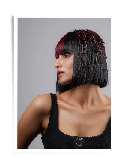 A bold and artistic look from our student Antara's portfolio. The sharp bob with red accents and intricate hair wiring demonstrates a high level of creativity and technical precision.