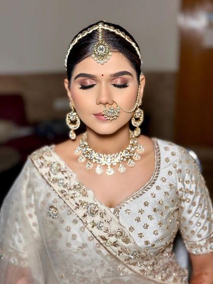 A serene bridal portrait featuring a classic bun adorned with baby's breath and a single white rose. This style is perfect for an elegant, minimalist bride.