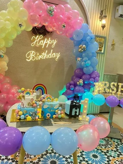A closer view of the rainbow-themed cake table, showing the two beautiful cakes that match the colorful decorations.