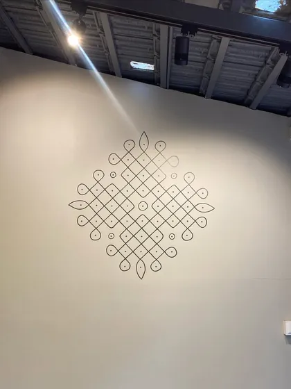 Kolam is a ritualistic art form from South India. We love painting these geometric patterns of lines and dots, which bring a timeless and elegant essence to any wall. This particular design on a grey wall stands out beautifully.