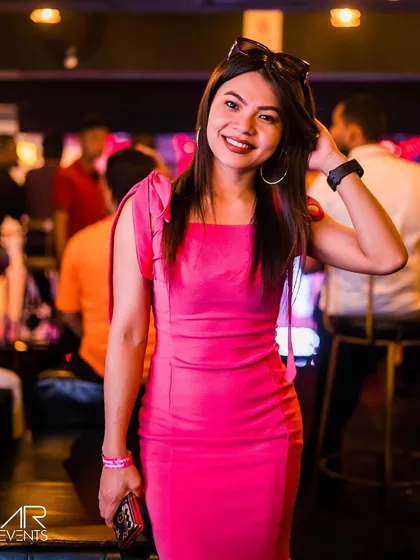 A guest in a vibrant pink dress, matching the party's energy.