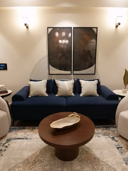 A perfect example of balancing color and texture. This living room setup features a bold navy blue sofa paired with soft, rounded boucle accent chairs. It's a modern, inviting space that shows our ability to play with different styles and materials.