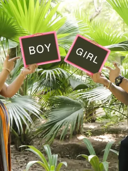 A playful "Boy or Girl" gender reveal photo from a maternity session in a lush green park. We help you capture the excitement of waiting for your new arrival.