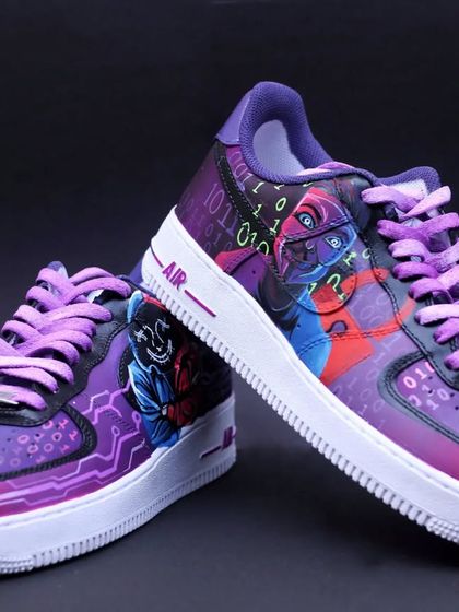 A pair for a hacker client. The design is dark and techy, with a purple and black theme, binary code, and circuit board patterns. The faded laces add to the shadowy vibe.