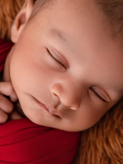 The peaceful face of a sleeping newborn is pure magic. This close-up shot is all about preserving those tiny, perfect details, from the soft skin to the delicate eyelashes, that you'll want to remember forever.