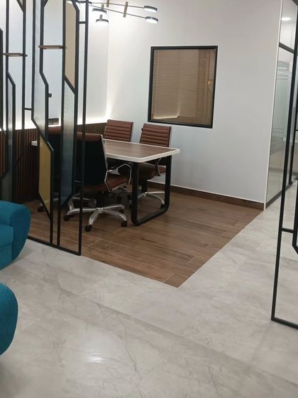 The completed meeting area in a CA office, showcasing the blend of different materials. The space features a custom metal partition, wooden flooring, and glass walls, creating a modern yet defined zone for discussions.