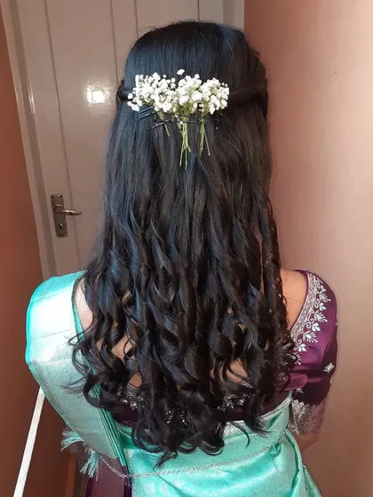The half-up style keeps the hair away from the face while still showing off its beautiful length and curls.