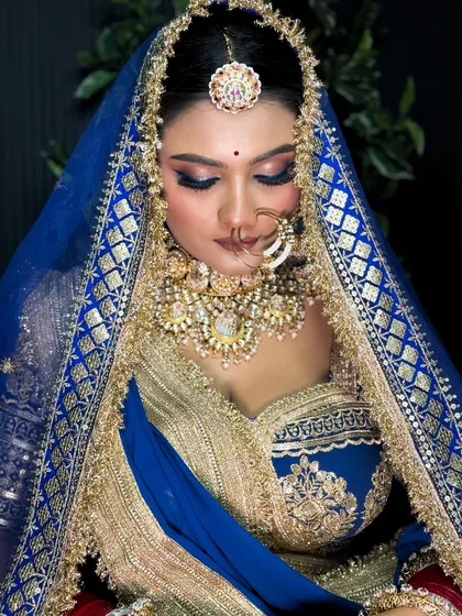 A beautiful shot with eyes closed, highlighting the detailed eye makeup with a pop of blue.