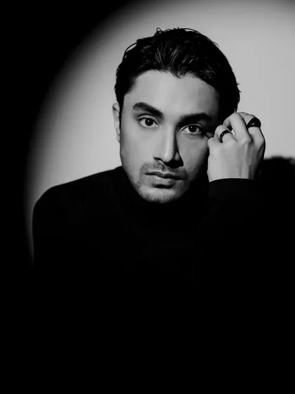 This portrait uses shadow and light to create a dramatic effect. The styling is minimal with a black turtleneck and rings to keep the focus entirely on the mood.