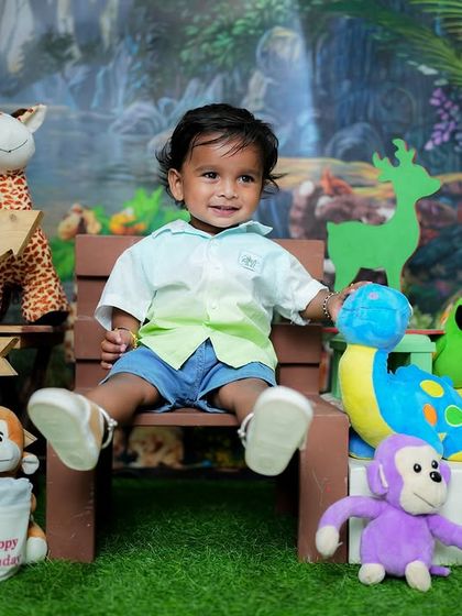 A joyful first birthday shoot with a vibrant jungle theme. Surrounded by friendly stuffed animals, this little one is all smiles on his special day.