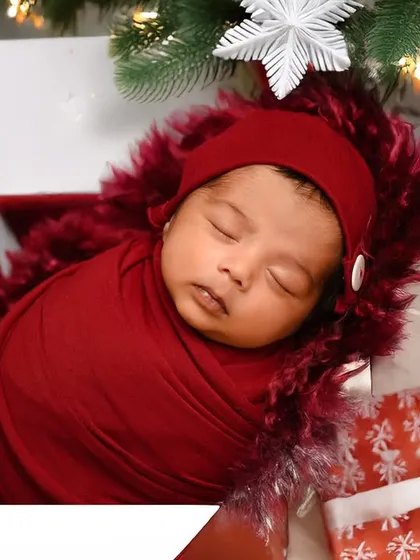 Another festive Christmas portrait, with the baby wrapped in red and sleeping inside a gift box under the tree. This makes for a perfect holiday announcement card.
