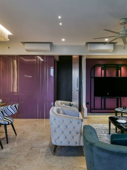 Color is a powerful tool for storytelling. In this Thane residence, I used a bold grape hue in both high-gloss and matte finishes to create a living area that is dramatic and artistic, balanced by soft, neutral fabrics and patterned accents.