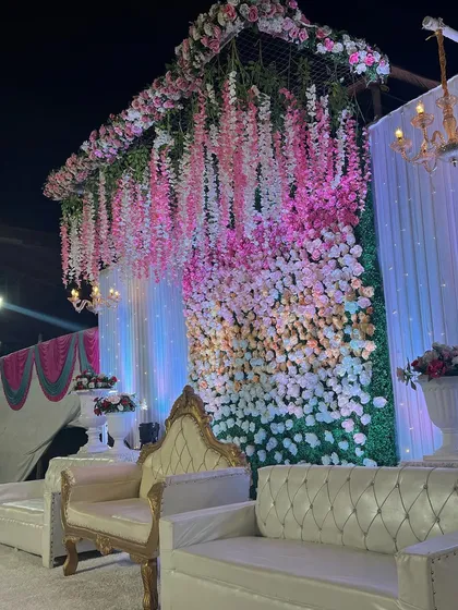A side view of the stage with hanging wisteria and an ombre flower wall. This angle shows the depth and texture I create in my backdrops.