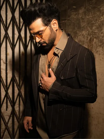 This shot captures the thoughtful details of the outfit, from the layered necklaces to the modern cut of the jacket. It's a look that is both contemporary and deeply rooted in style.
