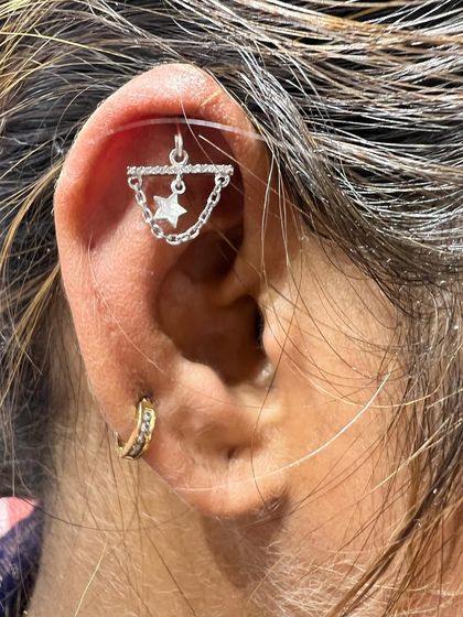 This edgy stack features a star hanging from a bar with a chain, creating an industrial-chic look.