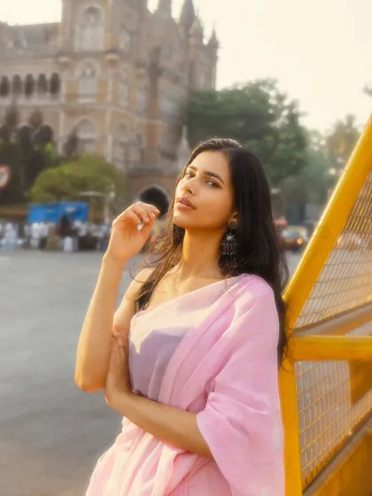Leaning against the barricade, this pose is more relaxed and contemplative, with the magnificent architecture of CSMT creating a grand backdrop.