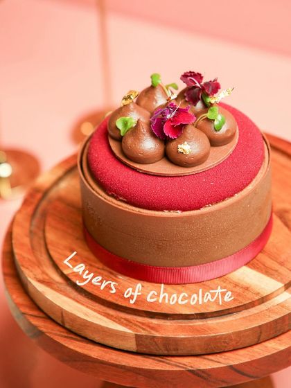 Layers of chocolate and strawberry goodness. This entremet features a rich red velvet finish and is topped with chocolate quenelles.