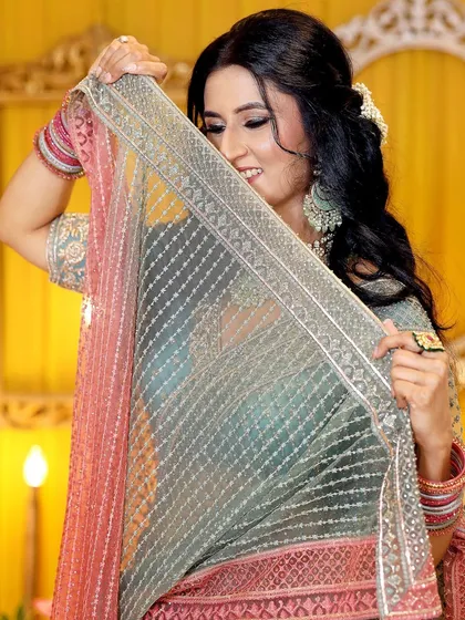 A playful and shy moment with the bride-to-be hiding behind her dupatta. These poses add a touch of traditional charm to the album.
