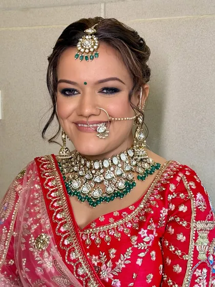 A joyful bride, her happiness lighting up the frame. The makeup is designed to look beautiful both in person and in photographs, capturing her glow from every angle.