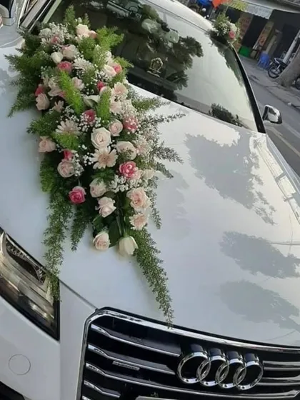 A sophisticated floral arrangement for a white Audi. This design uses a beautiful bouquet of pastel roses and lush greenery for a chic and elegant look.