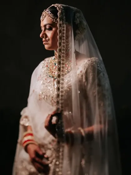 A classic bridal portrait, bathed in soft, golden light. The bride's serene expression and the delicate veil create a timeless and ethereal mood.