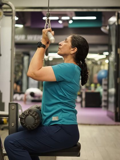 The lat pulldown is a fantastic exercise for building a wider back. Here, a member executes the move with precise form.