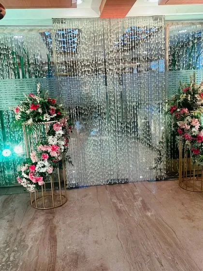 We use elements like these crystal curtains and tall floral stands to create stunning, light-filled backdrops that are perfect for photos at any celebration.