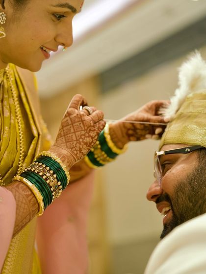 A playful and happy moment during a Marathi wedding ceremony. The bride's smile as she performs a ritual for the groom shows the joy and lightheartedness that we love to document alongside the solemn traditions.
