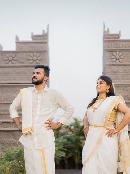A strong, poised stance from a couple in traditional attire against a grand, temple-like backdrop. This shot conveys a sense of regal partnership.