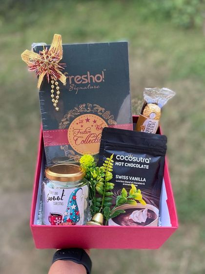 Indulgence in a box. This Christmas hamper is curated for the chocolate lover, featuring a Fresho Signature collection, Swiss vanilla hot chocolate mix, a jar of sweets, and a single Ferrero Rocher for that extra touch of luxury.