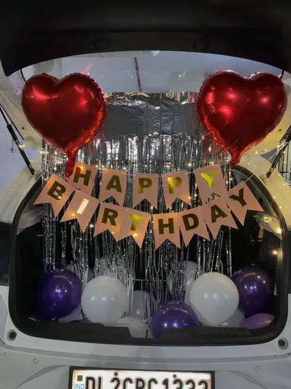 Another look at the birthday car boot decoration, with a 'Happy Birthday' banner, balloons, and fairy lights.