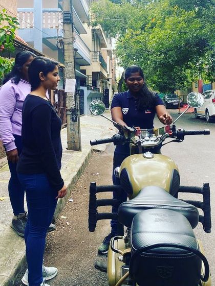 A female coach demonstrating proper technique. It's important for students to see women confidently handling these bikes, reinforcing that they can do it too.