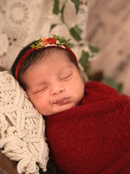 The texture of the macrame pillow and the soft red wrap adds depth to this close-up portrait from the rustic camper session.