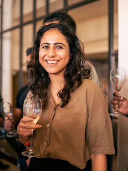 A guest enjoys a glass of wine, her smile reflecting the warm and welcoming atmosphere of my crafthouse.