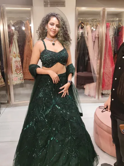 A happy client with gorgeous curls looking stunning in our emerald green sequin lehenga. It's a perfect look for a cocktail or sangeet night.