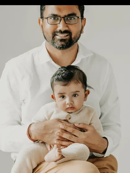 The bond between a father and his child is so special. This simple, clean portrait focuses on that gentle connection, with the baby looking right at the camera, safe in her father's arms. These are the quiet moments that hold so much love.