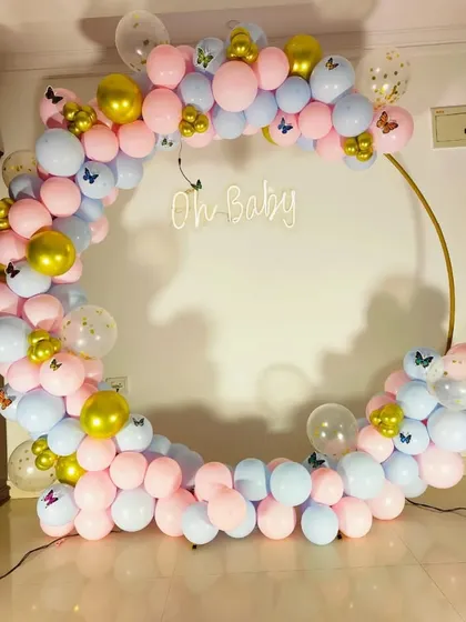 A close-up of the pink and blue balloon arch, decorated with small butterfly accents for a delicate touch.