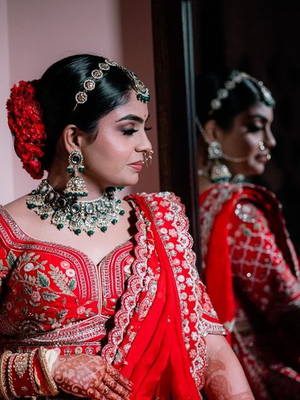 A bride looking at her reflection in the mirror. This is a classic getting-ready shot that captures a moment of anticipation before she walks down the aisle.
