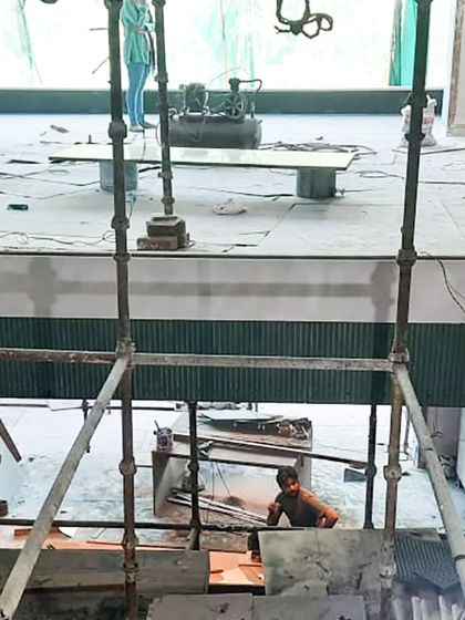 A view from above on a multi-level construction site. Scaffolding provides access as our team works on the interior finishes of a double-height space.
