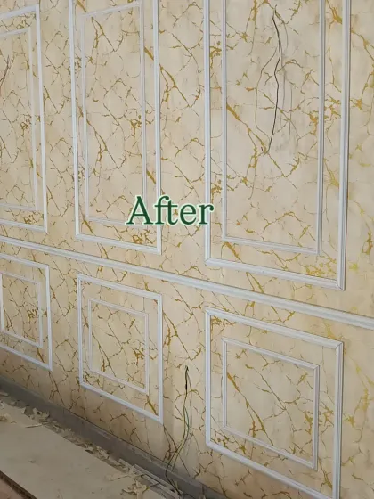 This is the finished look of a wainscoting project. I used white moulding to frame a luxurious gold-veined marble wallpaper, giving the entire wall an elegant and high-end appearance.