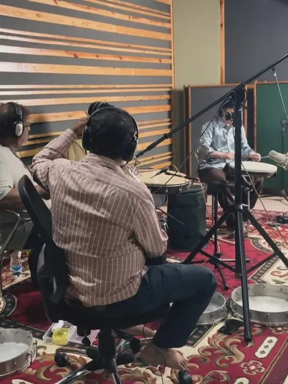 A behind the scenes shot of the folk rhythm section listening back to a take. The collaborative process involves everyone listening and contributing ideas.