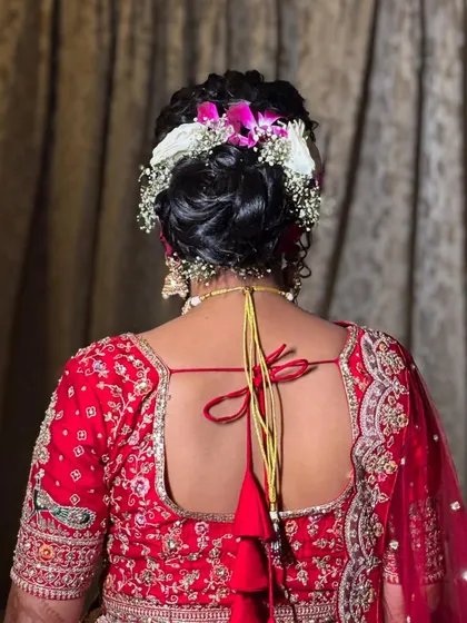 A view of the back of the bride's head, showing the beautiful floral bun hairstyle. I love creating intricate hairstyles that complement the overall bridal look.