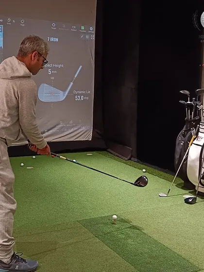 A client takes a practice swing in the simulator. This controlled environment is perfect for isolating variables and testing different club configurations.