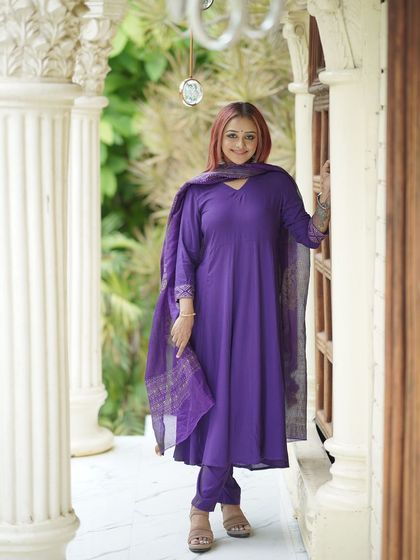 A classic, full-length portrait of the model against the white pillars and window.